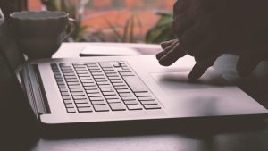 homme analysant des documents légaux avec un ordinateur et une carte de crédit pour illustrer la vente en ligne et la conformité légale